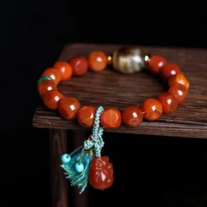 South Red Agate Pixiu Dzi Bead Bracelet - Premium Handcrafted Wealth Prosperity Stone with Turquoise Tassel and Red Pixiu Charm on Wooden Display