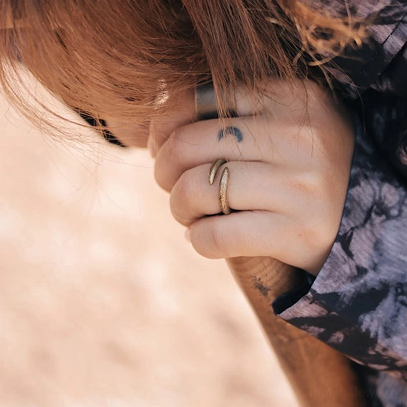 Vintage spiral copper ring worn stacked on multiple fingers in casual daily wearing style