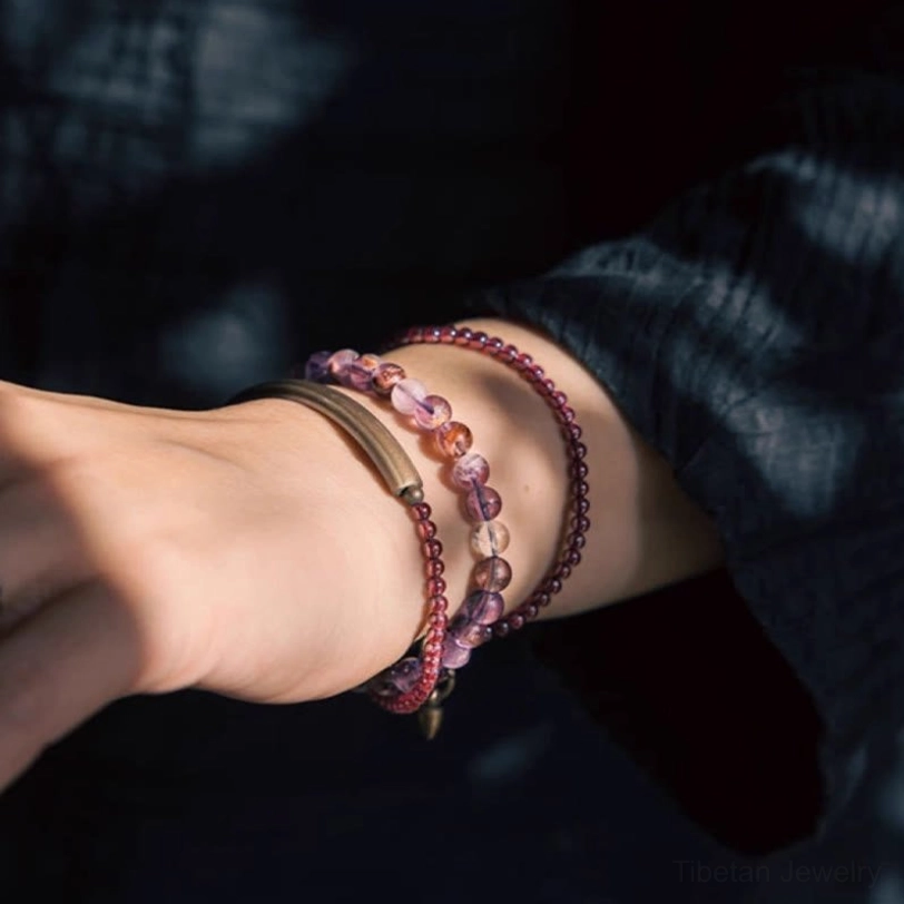 Multilayer amethyst and garnet spiritual bracelet with drop pendant on textured background