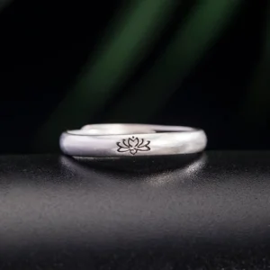 925 sterling silver lotus flower ring with adjustable open band, front view on dark leather background