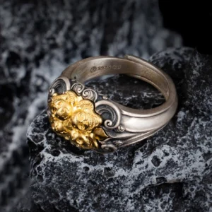 Close-up side view of sterling silver Tibetan skull ring showing S925 stamp and carved scroll patterns on textured stone surface