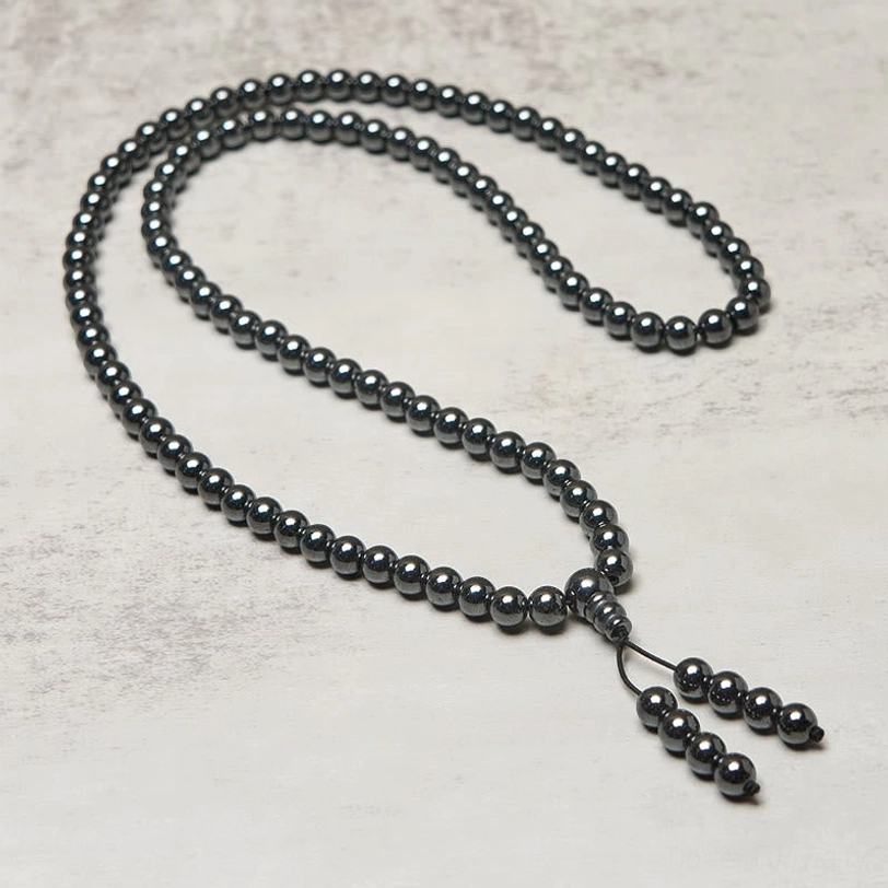 Full length terahertz mala strand stretched out showing all 108 beads with long tassel pendant