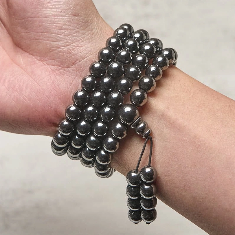 Terahertz mala worn on wrist with multiple wraps and hanging tassel close-up side view