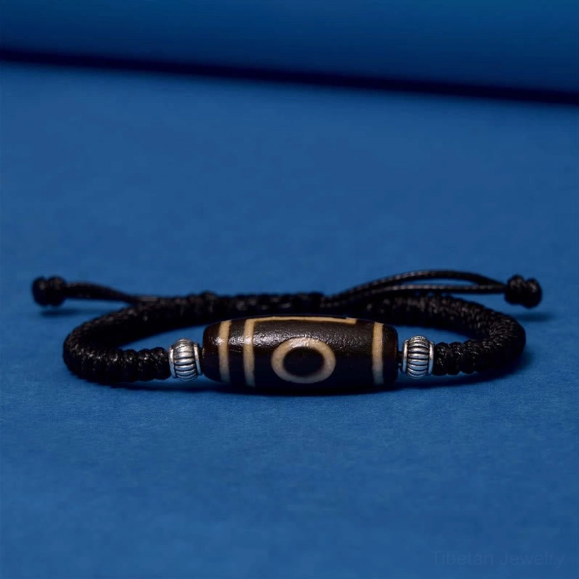 Tibetan three-eye dzi bead bracelet full length view highlighting braided cord quality and bead centering