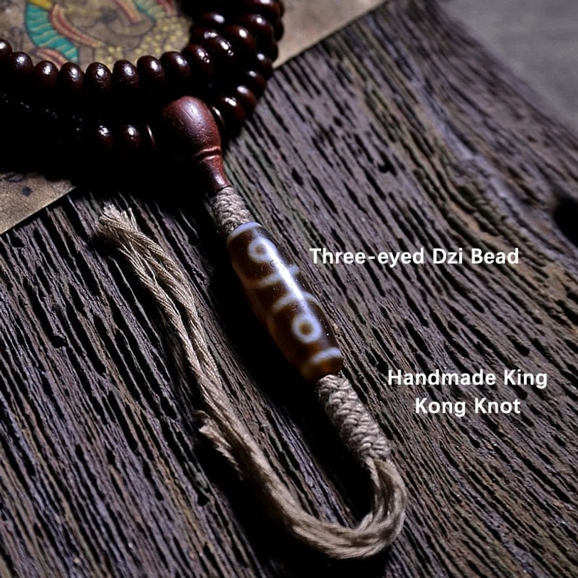 Three-eyed dzi bead detail on Tibetan mala bracelet for protection and prosperity