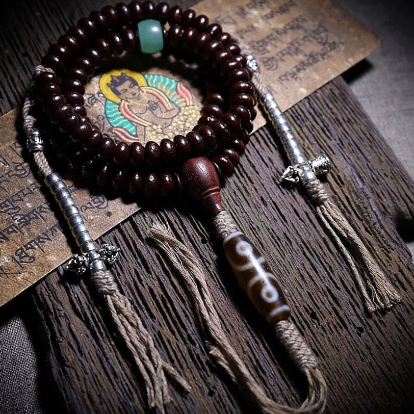 Hand-knotted Tibetan mala with bodhi seeds, protective dzi bead, and copper dorje charm on scripture board