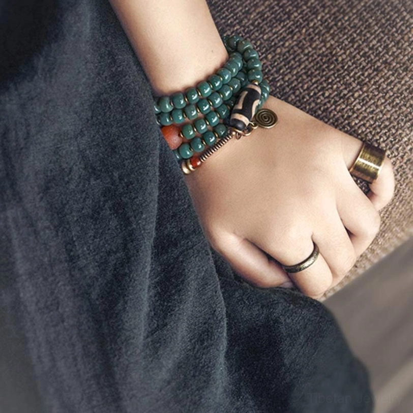 Single Tibetan 108 Mala Prayer Necklace with Striped Dzi Bead on Dark Linen