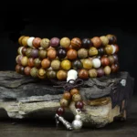108 natural wood mala beads meditation necklace overhead view with multi-tone wooden prayer beads and silver charms