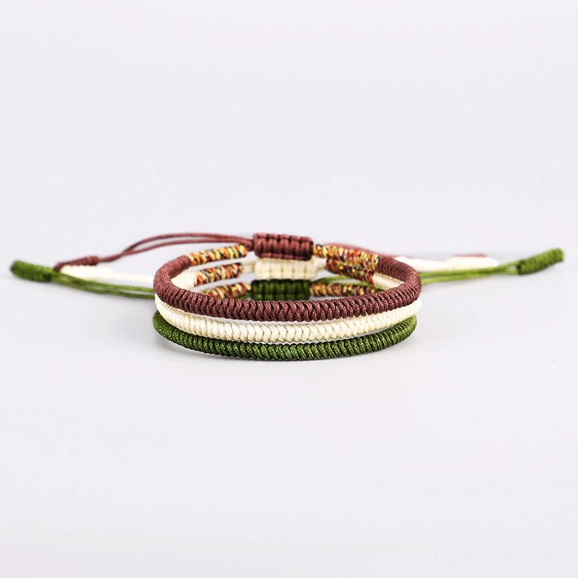 Three-layer Tibetan woven bracelet in brown, dark green, and off-white with central colorful protective knot
