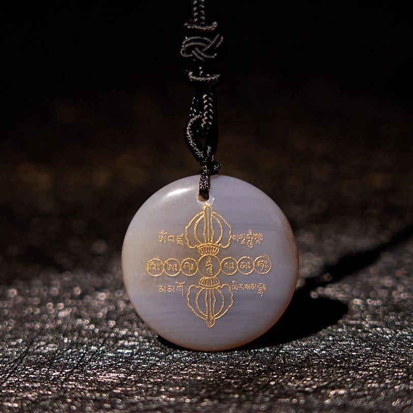 Agate Vajra Dorje Tibetan necklace pendant with golden Sanskrit patterns and black braided cord