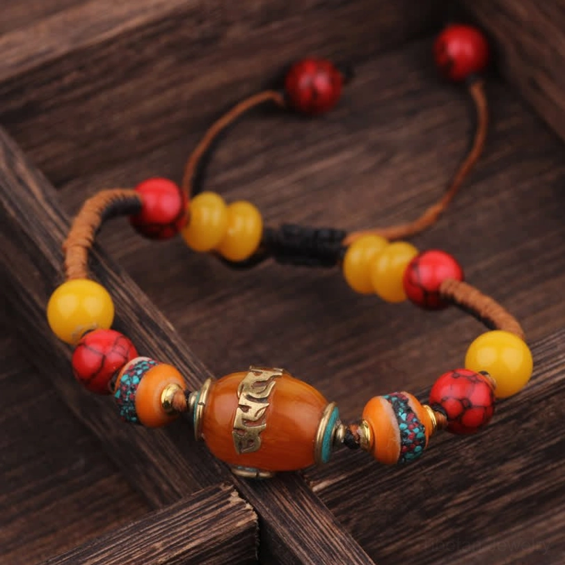Brown braided cord Tibetan bracelet with amber center stone and mixed gemstone beads angled view
