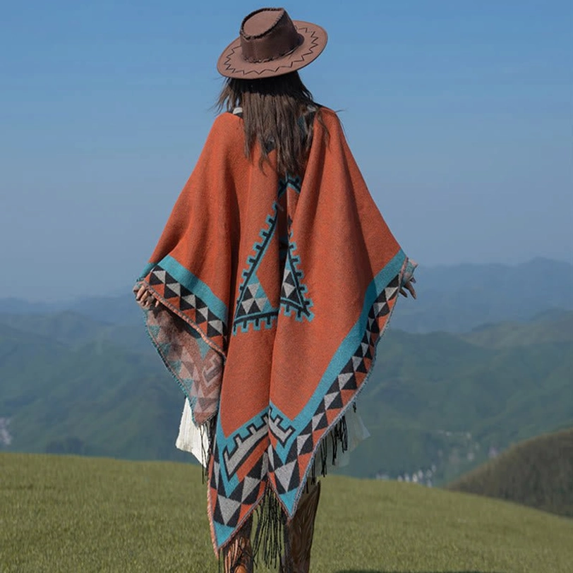 Back full view of Aztec-style tassel shawl showcasing geometric triangle patterns across back and terracotta base color