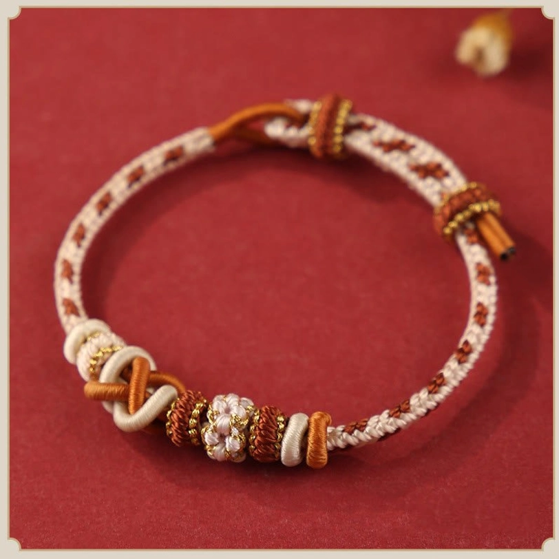 Beige and earth tone tibetan peace knot bracelet with brown and gold threads, natural grounding energy flat lay
