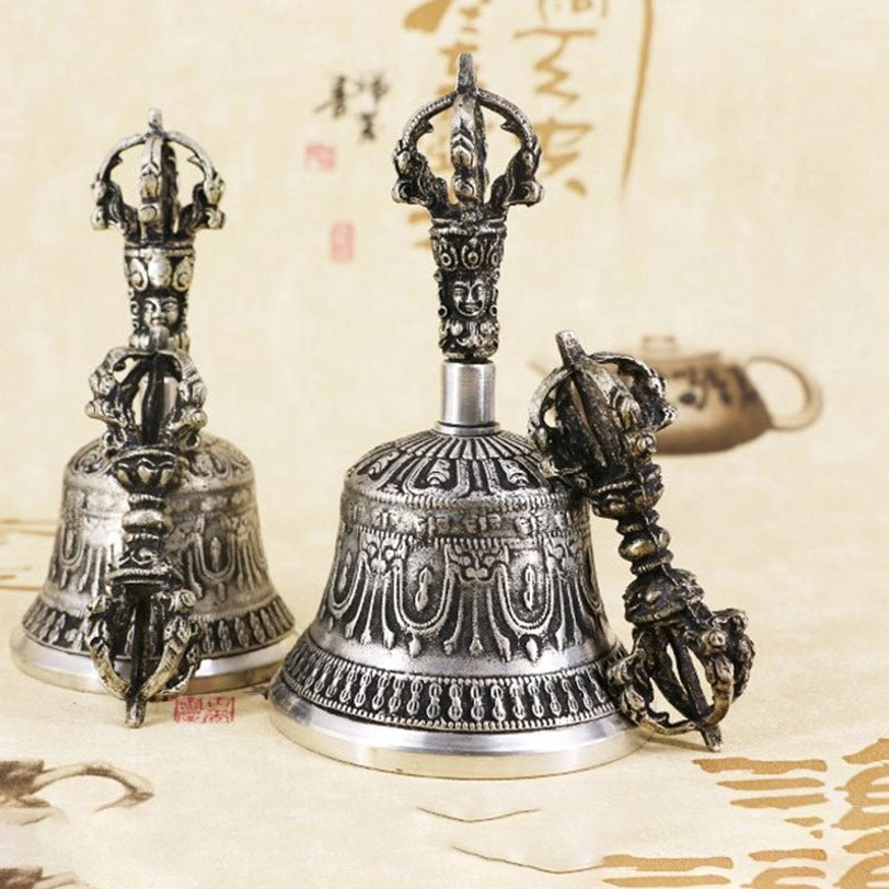 Tibetan meditation bell and vajra dorje positioned on yoga mat and cushion showing use in mindfulness and meditation practice environment