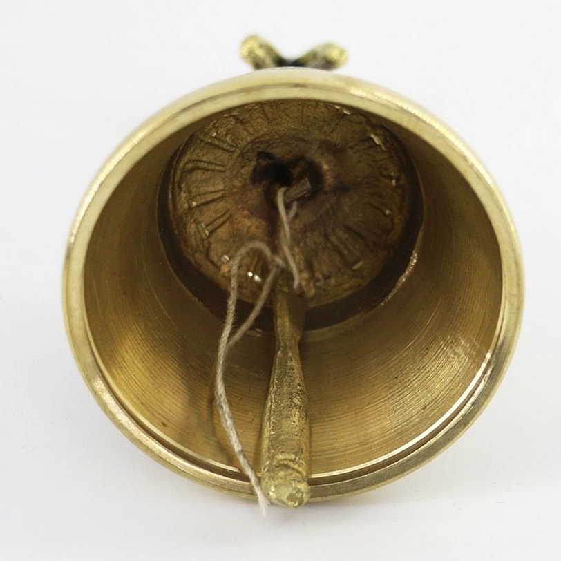 Interior view of Tibetan meditation bell showing brass clapper and hanging string - inner bell construction