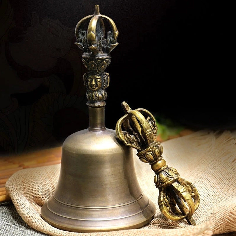 Handmade Tibetan meditation bell and vajra dorje set in antique bronze copper, displayed on burlap and wooden mat backdrop