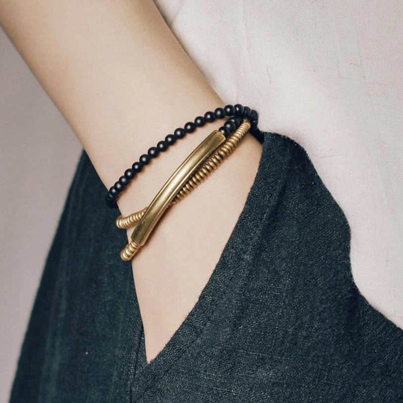 Black agate Tibetan minimalist bracelet side close-up showing curved brass cuff on daily casual wear