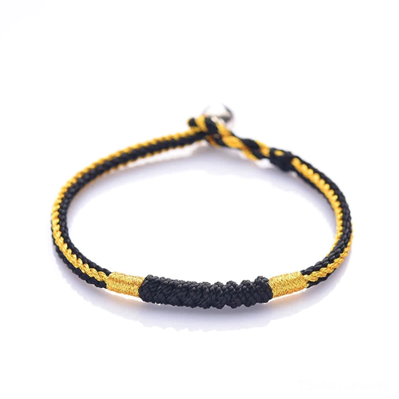 Black and gold Tibetan handmade braided protection bracelet with thick woven section and silver metal clasp