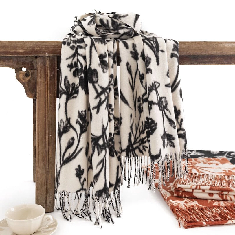 Black floral Tibetan shawl with cream base hanging display, showcasing authentic tassel trim and artistic flower patterns