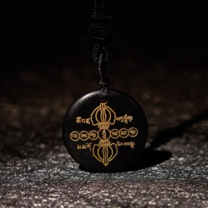 Front view of Vajra Dorje black obsidian crystal pendant with intricate golden Sanskrit and Dorje patterns, flat lay on glittery background