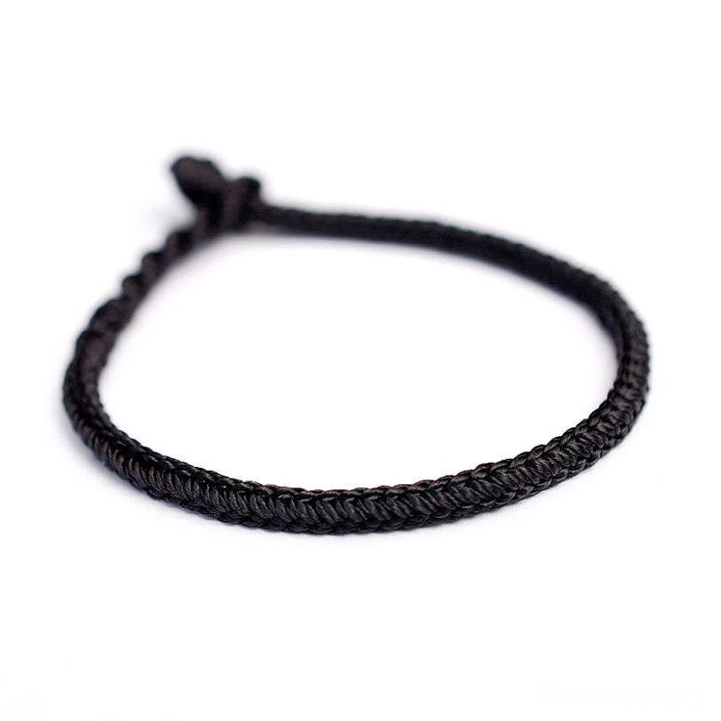 Black tibetan eight-thread peace knot protection bracelet flat view on white background with tight woven rope pattern
