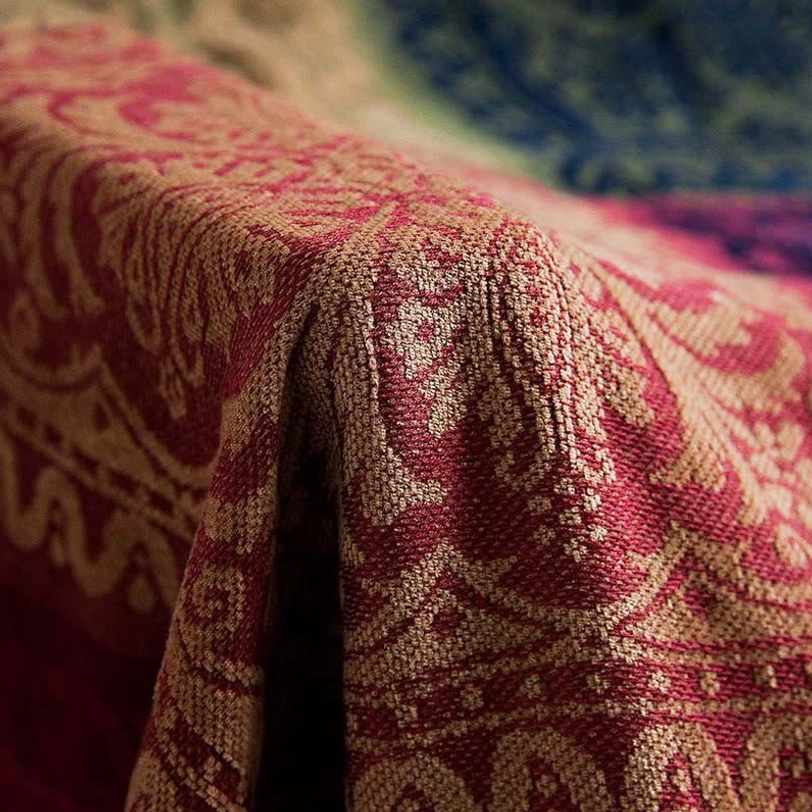 Close-up texture detail of Tibetan handwoven blanket showing damask jacquard weave in red and tan colors
