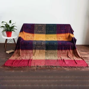 Overhead view of Tibetan-inspired woven blanket with checkered block print design on minimalist living room floor