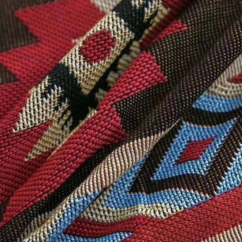 Tibetan geometric blanket 3D jacquard weave close-up showing multi-color ethnic patterns and dimensional textile