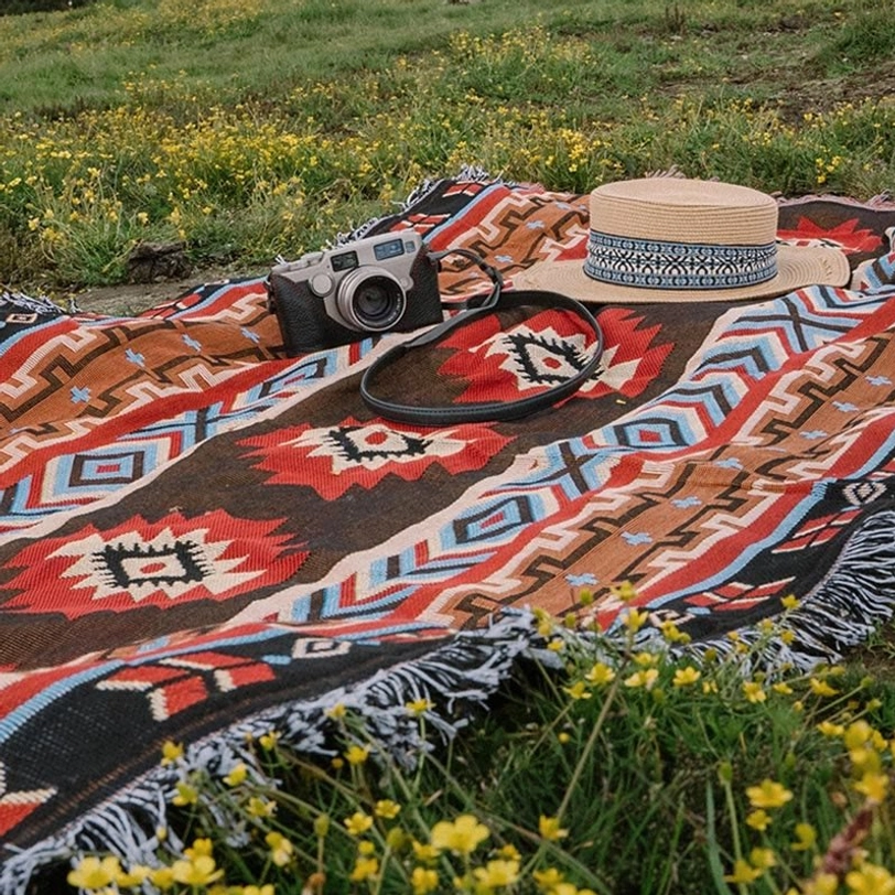 Outdoor picnic scene with Tibetan geometric throw blanket on grassland showing retro ethnic patterns and fringed border