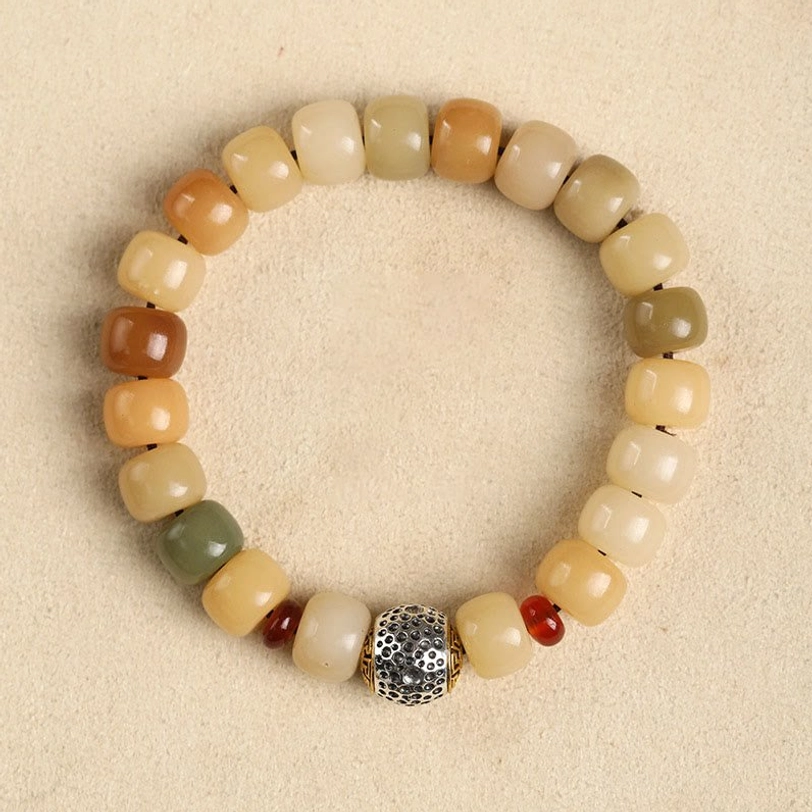 Tibetan blessing bodhi seed bracelet, flat lay overhead view with gradient earthy beads and detailed metal charm on light background