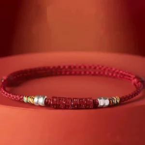 Tibetan red cord bracelet close-up side view showing colorful woven knots and polished silver beads