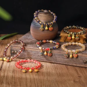 Assorted swallowing beast charm beaded bracelets in multiple colors with pottery vase display