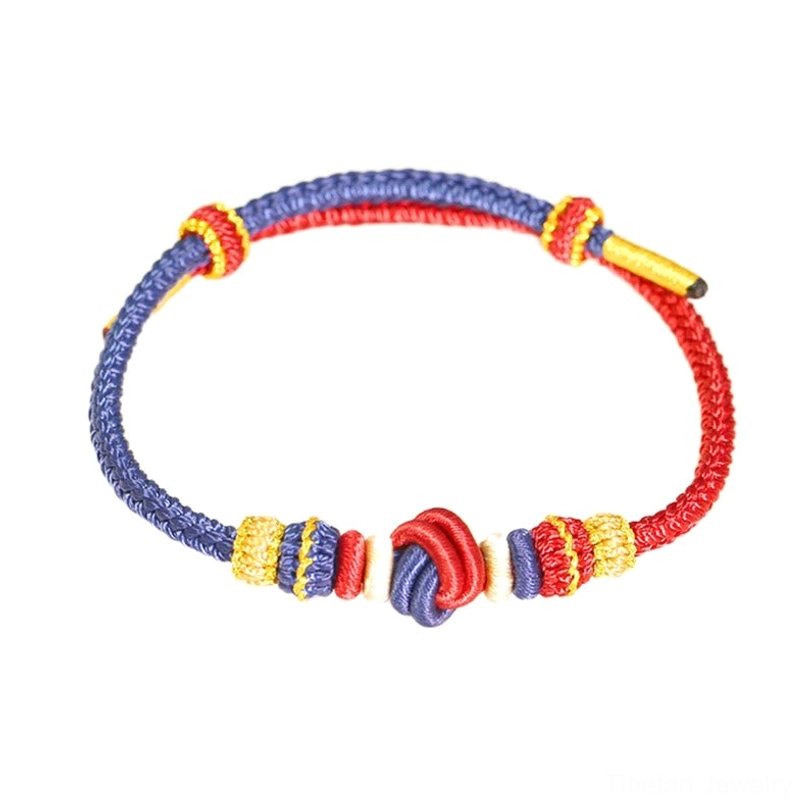 Handcrafted Tibetan eight-thread peace knot bracelet with red and blue rope and adjustable golden accent details