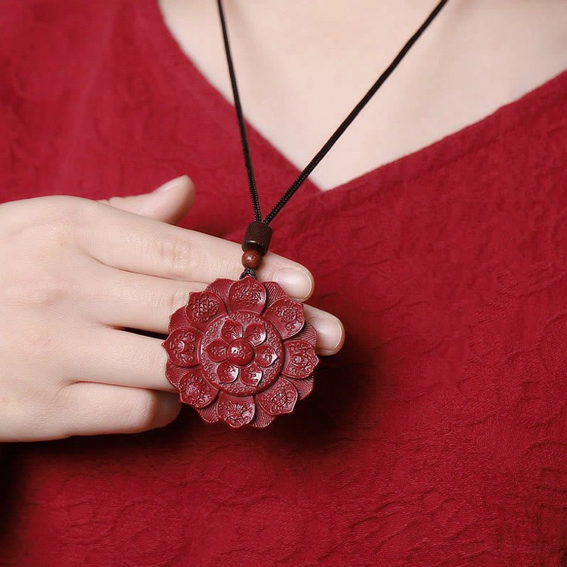 Tibetan lotus pendant necklace worn on black waxed cord, displayed on chest with hand showing wearing effect
