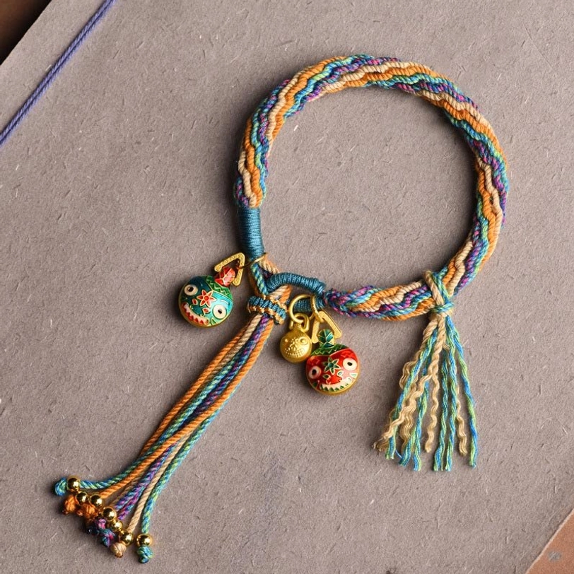 Blue and green Tibetan reincarnation knot bracelet with enamel beast charm and colorful tassel accents