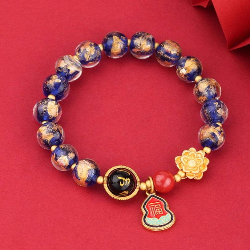 Full Tibetan Om Mani Padme Hum bracelet in blue spotted Liuli glass with complete charm set on solid background