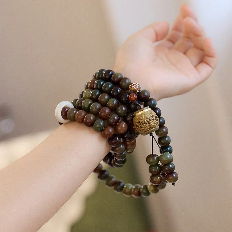 Tibetan bodhi seed mala bracelets stacked on wrist showing earth-tone beads and protective Dzi stone detail