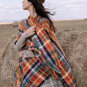 Warm-toned Tibetan striped shawl draped on shoulder outdoors, side view showcasing cozy soft fabric texture and fringe hem detail