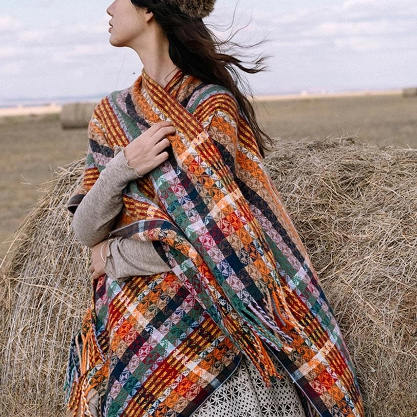 Warm-toned Tibetan striped shawl draped on shoulder outdoors, side view showcasing cozy soft fabric texture and fringe hem detail