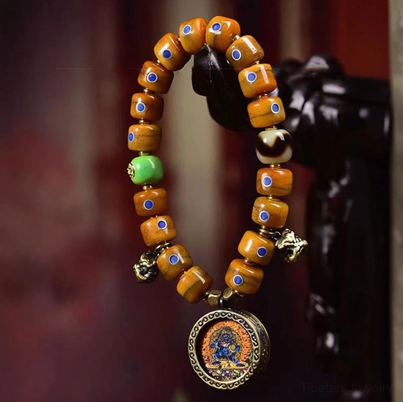 Vintage Tibetan bone bead bracelet with blue inlay details, close-up hanging display