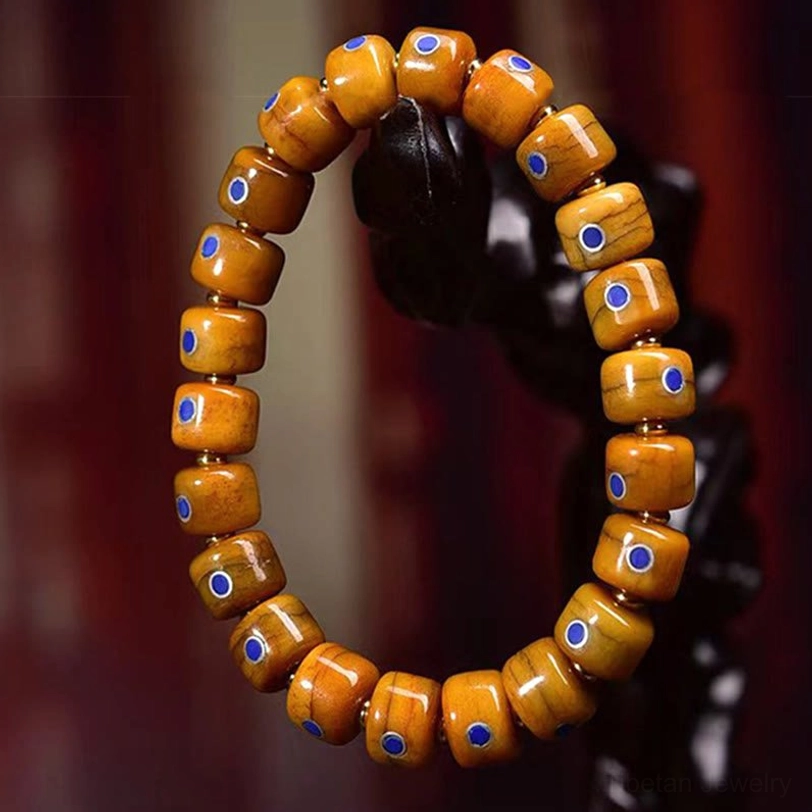 Handcrafted Tibetan bone beaded bracelet with blue-white dot inlays on display holder