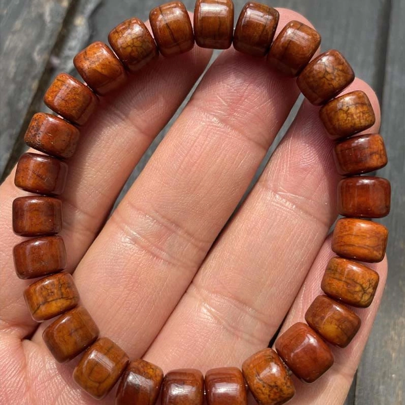 Close-up eye-level view of Tibetan bone bead bracelet with natural grain on palm