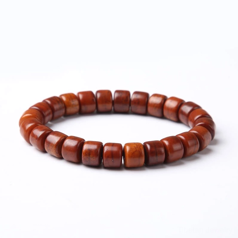 Single Tibetan bone bead bracelet neatly arranged overhead shot white background