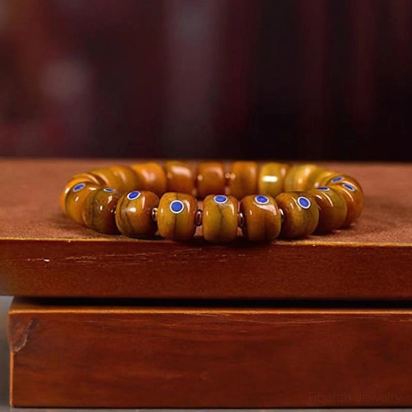 Tibetan spiritual bone bead bracelet laid flat on stacked wooden boxes