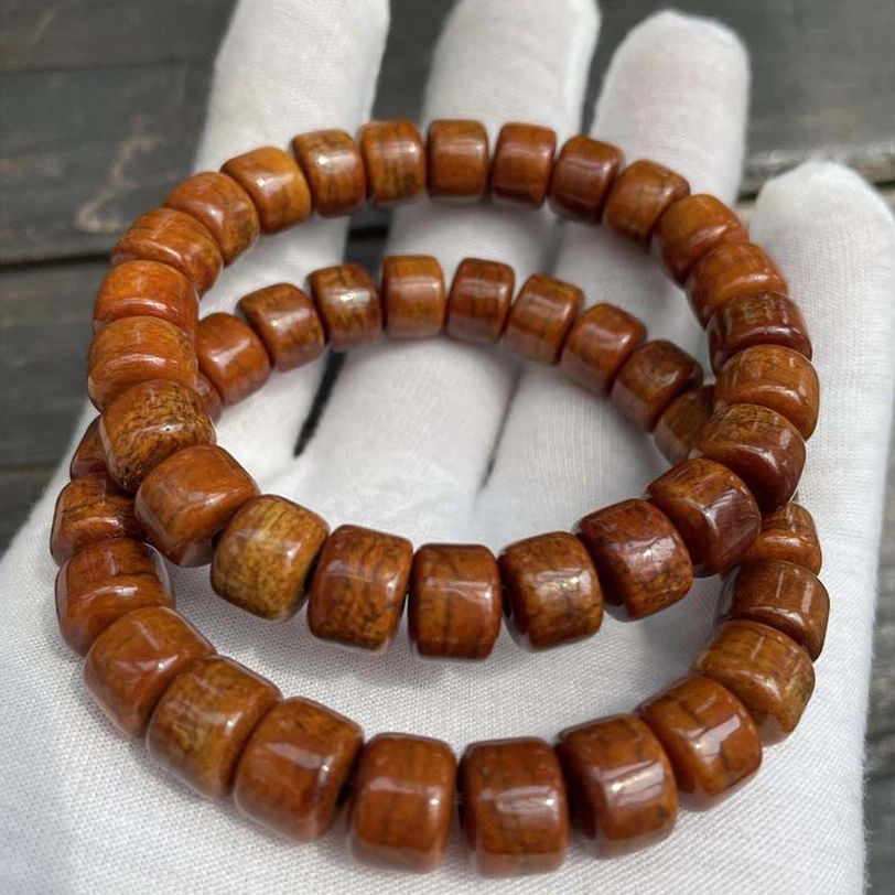 Tibetan bone bead bracelets matte finish on white gloves wooden tabletop display