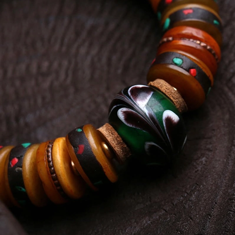Detailed side view of marbled bone beads with green-black accent and brown bone discs on Tibetan bracelet