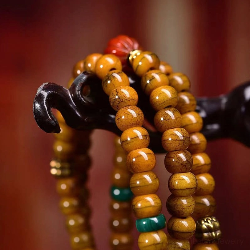 Close-up macro view of Tibetan bone beads with green and red spacer agate accents and metal decorative elements