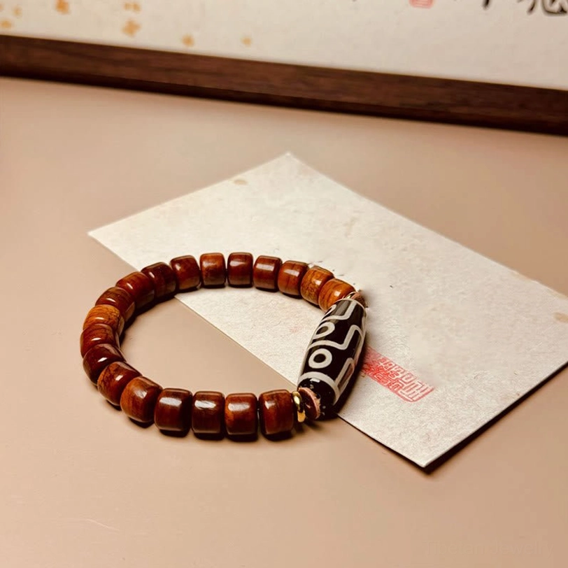 Tibetan bone Dzi protection bracelet angled view with metal clasp and red seal stamp