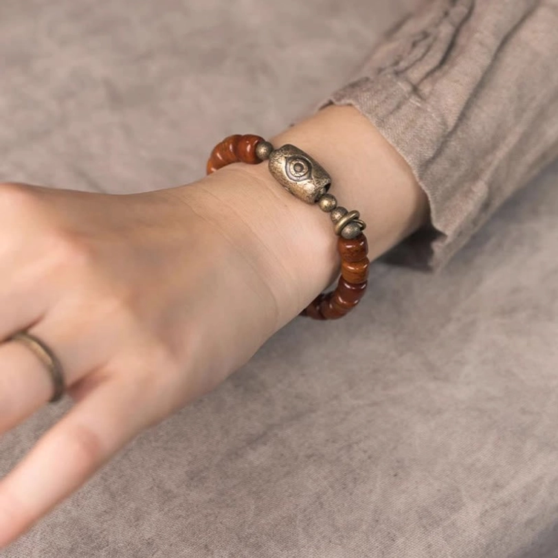 Tibetan bone Dzi protection bracelet with copper cone pendant and eye charm, natural artisanal handcrafted design showcase