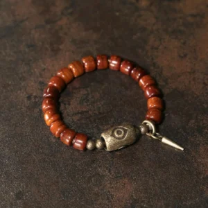 Tibetan Dzi bracelet side angle showing premium elastic string, dangling copper cone pendant and open metal clasp detail